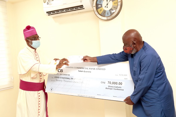 FLASHBACK: Mr Jude Kofi Bucknor (right), a member of the Board of Trustees of Covid-19, receiving a dummy cheque for GH¢70,000 from Archbishop Gabriel Palmer Buckle (left), Vice-President of the Catholic Bishops Conference