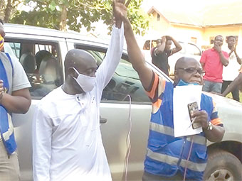 Mr Seth Kofi Darko (right), an officer of the Electoral Commission,  holding up Mr Wiredu’s hand to declare him the winner