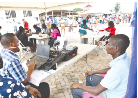 A young man (right) going through the process to register at Gbegbeyise at Dansoman in Accra. Picture: EBOW HANSON