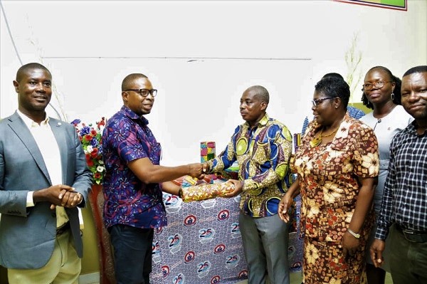 Mr Kwasi Baiden (second left) presenting the items to Prof. Frederick Kwaku Sarfo, Principal of the COLTEK