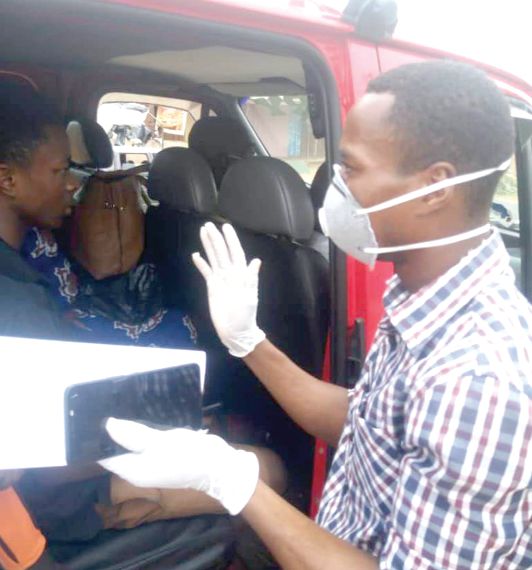 A health official educating a driver and passengers in a  vehicle