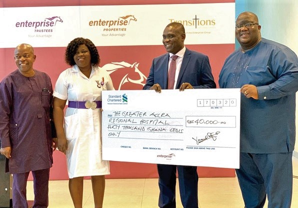 Mr Daniel Larbi-Tieku (2nd right), assisted by Mr Joseph Ampofo (right), MD, Enterprise Trustees, to present a dummy cheque to Ms Rebecca Agyare-Asante (2nd left), Head, Nursing and Midwifery, Ridge Hospital