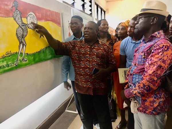 Ben Agbee, one of the artists in the exhibition, making a point about one of his works to the Guest of Honour at the opening, Nana Fredua-Agyeman Ofori-Atta (in hat).