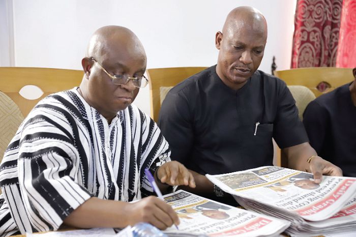  Dr Archibald Yao Letsa (left) autographing the first copies of the Saturday edition of the Daily Graphic which has the Volta Regional Spotlight. Looking on is Mr Ato Afful, MD of the GCGL