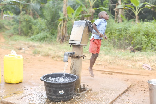 A child drawing water from a borehole