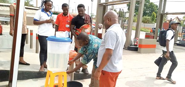 The Agona West Municipal Environmental Health and Sanitation Officer, Mr George Freeman, demonstrating proper hand washing to the staff of one of the Total Filling Stations during the sensitization in Agona Swe