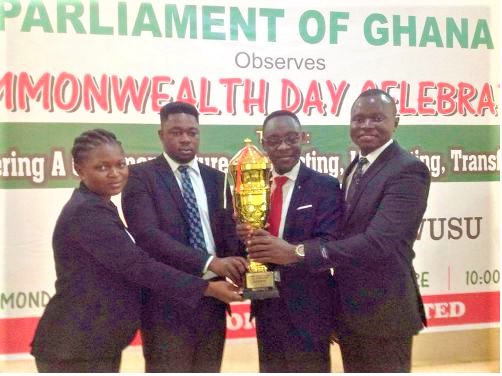 The Principal Speaker of the CUC, Patrick Okrah Danso (right), and Daniel Egel (2nd left) proudly displaying the golden trophy with their team members after emerging the best in the debate. 