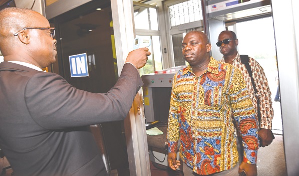 A security man checking the temporature of MPs at Parliament as part of measures to curb the sread of the coronavirus.