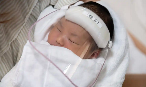 Three-day-old Kengo Saito wears a face visor to protect against Covid-19 on May 15, 2020 in Satte, Japan. Photograph: Carl Court/Getty Images