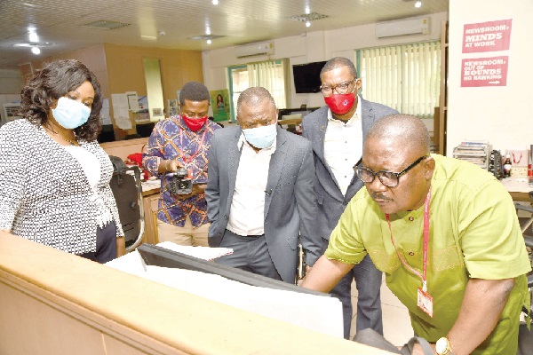 Mr Vance Azu (right), the Night Editor, Daily Graphic, taking Mr Alhassan Andani (3rd right) through one of the  processes involved in the production of the paper  during his visit to the newsroom. Looking on are Mrs Mavis Kitcher (left), Director, News, and Mr Kobby Armah (2nd right), Editor of the Daily Graphic. Picture: EBOW HANSON 