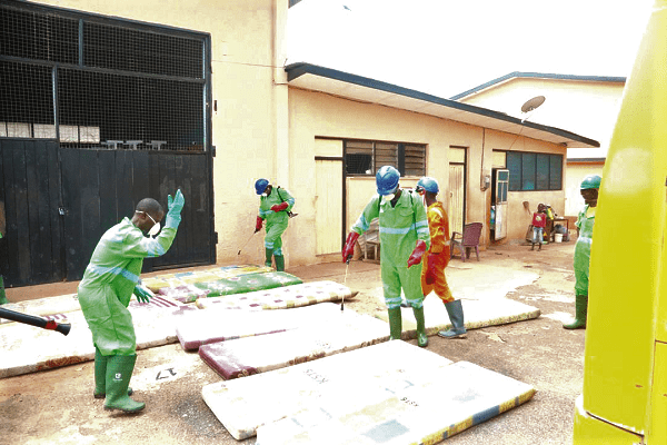 Some staff members of Zoomlion disinfecting the mattress beds of the students