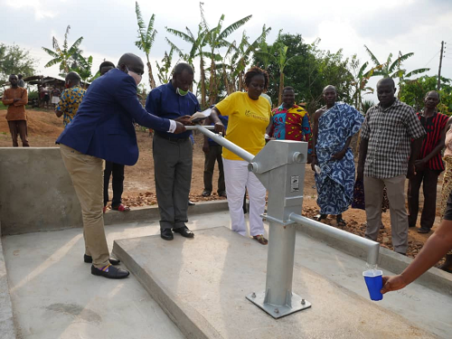 Madam Gladys Afua Kwatema Yamoah, CEO of Action Against Rural Poverty(right) being assisted by Mr Alex Inkoom(left), the DCE of Asene-Manso-Akroso District to commission one of the boreholes.