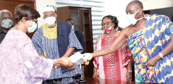 Justice Sophia Akuffo (left), Chairperson, National COVID-19 Trust Fund, receiving the cash donation from Nana Otuo Siriboe (right), Chairman, Council of State.