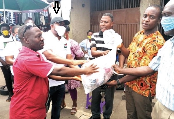 Mr  Mathias Alagbo (arrowed), the Volta Regional Youth Organiser of the NDC,  presenting some of the face masks to beneficiaries