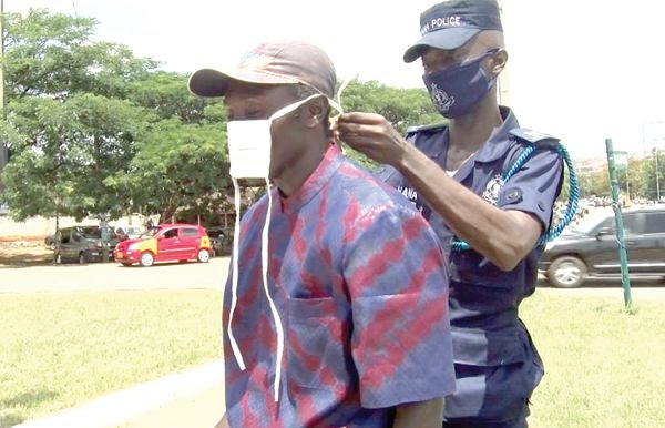  A policeman helping a member of the public to put on his nose mask 