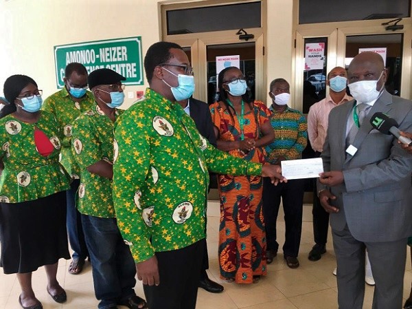  Mr Kwaku Agbesi (4th left), presenting the cheque to Nana Effah Apenteng (right), while other dignitaries look on