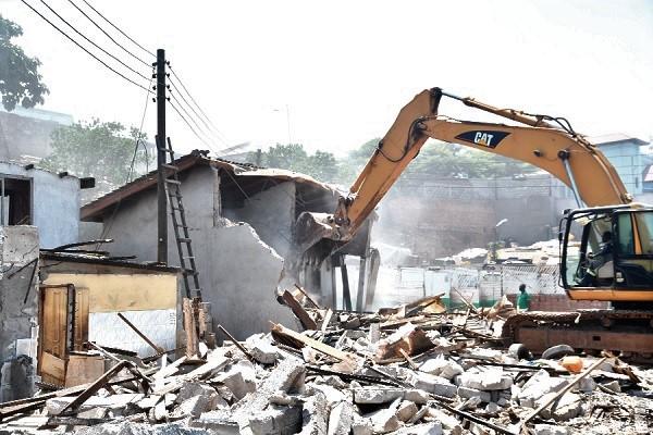 An excavator demolishing structures at the James Town beach. Picture: EBOW HANSON