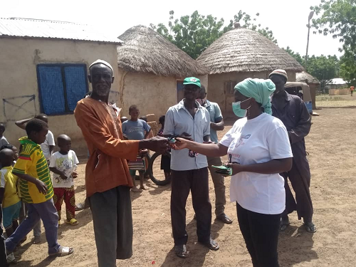  Madam Mahamuda (in white shirt) distributing face masks to some members of the community