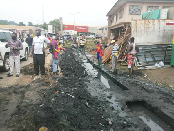 Members of the team clearing a choked gutter at Asafo
