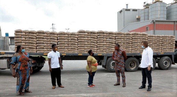 Mr Richard Darko (2nd right) presenting the cement (on the truck) to Mrs Joyce Lamptey. Looking on is Mr Frederick Albrecht (right)