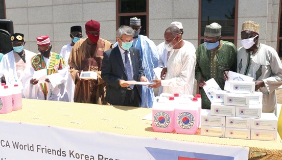 Mr Sungsoo Kim (left) presenting the items to Mr Abubakar Saddique Boniface