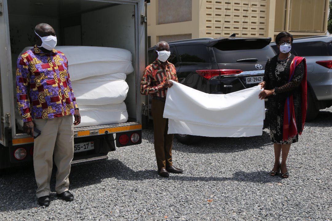 Mrs Sophia Akuffo, Chairperson, National Covid-19 receiving some of the 6000 yards of bleaching cloth for the production of face mask from Rev. Stephen Adu, Marketing Director, GTP in Accra. Picture: SAMUEL TEI ADANO