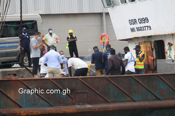 Officers of the Fisheries Commission and the Ghana Marine Police with executives of the arrested vessel going through arrest procedures