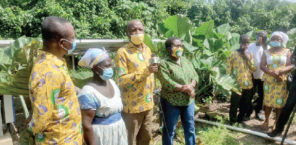 Mr Francis Lanquaye (3rd left) explaining to farmers how the technology has improved his cocoa produce.  With him are Mrs Yaa Amekudzi (middle) and other farmers