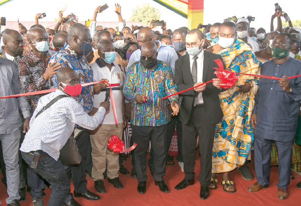 President Akufo-Addo being assisted by Mr Emad Deraz (3rd right) and Daasebre Okogeaman Duodu Ampem II (2nd right) to cut a tape to inaugurate the Tain District Hospital at Nsawkaw. With them are Mr Kwaku Agyeman Manu (5th right) and Dr Owusu Afriyie Akoto (right), the Minister of Food and Agriculture. INSET: Front view of the Hospital