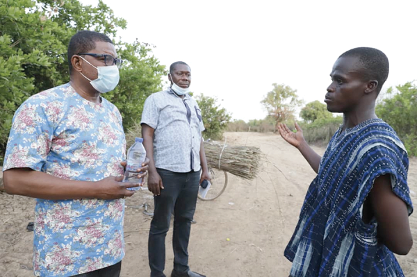 Mr Alhassan Yussif (right) explaining to Mr Kobby Asmah, Editor, Daily Graphic, how the community was flooded. With them is Samuel Duodu, Graphic Reporter