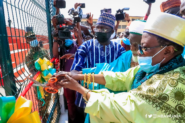 Vice-President Bawumia (left) being assisted by Sheikh Osman Nuhu Sharubutu (middle) to cut the tape to inaugurate the sports complex in Accra.