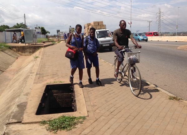 Students of the Police Depot JHS walking close by an open underground chamber at Avenor. Picture: Nana Konadu Agyeman
