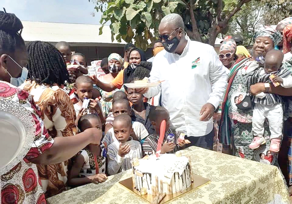 Former President John Dramani Mahama sharing his birthday cake with children at the Nyohini Children's Home in Tamale