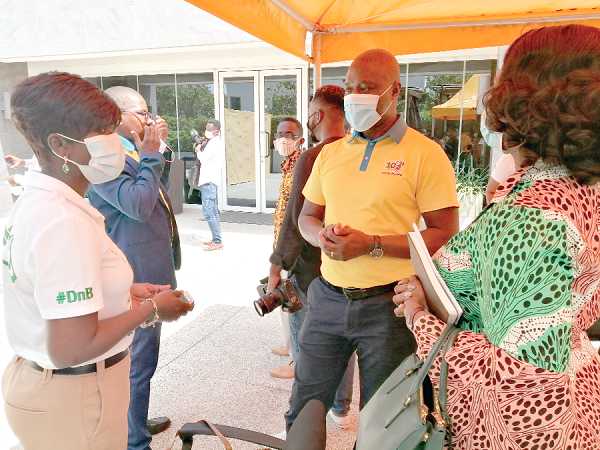  Mr Eli Hini (middle) interacting with Madam Ama Bawuah (right), Executive Chairman, GG&amp;B Brokers, and Mrs Jacqueline Benyi (left), after the launch