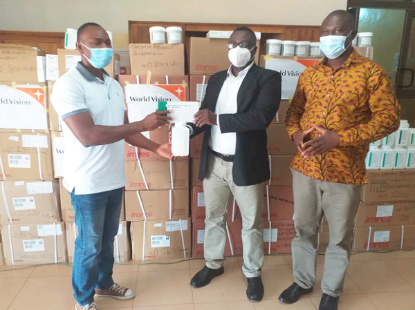 Mr Timothy A. Akanpabadai (left) presenting the items to Dr Dominic Otchere (middle). With them is Dr Chrysantus Kubio