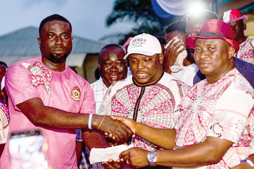 Mr Bernard Botchway (left) presenting the money to Mr Akwasi Acquah (right). Looking on is Alhaji Awudu Issaka, the Oda Constituency Chairman of the NPP