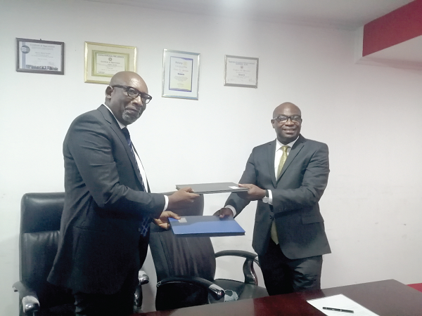 Mr Daniel Kissi (right) exchanging the MoU with Mr Johnnie Allotey 