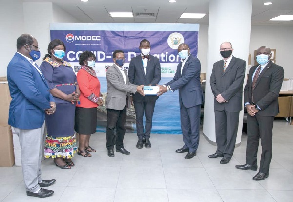 Mr Theophilus Ahwireng (3rd right), Managing Director of MODEC Production Services, handing over part of the package to Prof. Richard Phillips (4th left), Director of KCCR, while other officials look on
