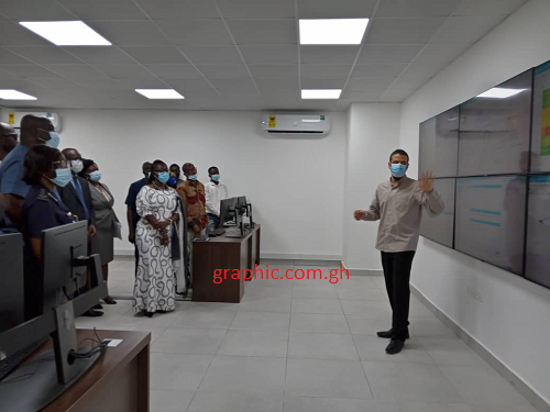 A staff of GDS, Ash Dastmalchi explaining how the SOC works to the Minister of Communications, Mrs Ursula Owusu-Ekuful and some dignitaries at the launch 