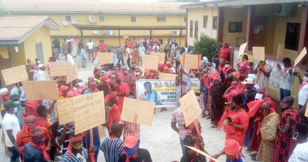 Red-clad demonstrators marching through the streets of Tarkwa to demand the reinstatement of the Nana Odeneho Akrofa Kukroko II