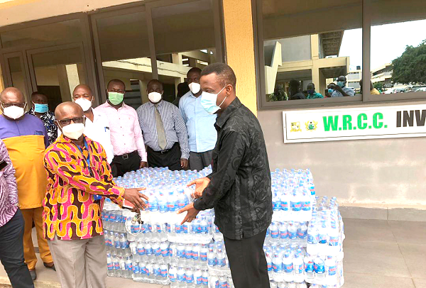 Mr Kwabena Okyere Darko-Mensah (right) receiving the packs of water from Nana Yaw Barnie