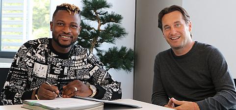 Patrick Twumasi (left) putting pen to paper