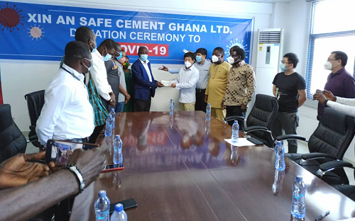 Zhou Jinhua, the General Manager of Xin An Safe Cement presenting the cheque to Martin Sarfo, Head of the Health Directorate