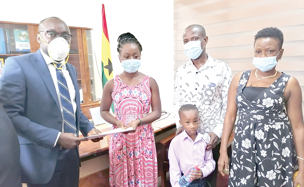 • Mr Kingsley Agyemang (left) presenting the scholarship package to Charlotte Duako Somuah (2nd left) 