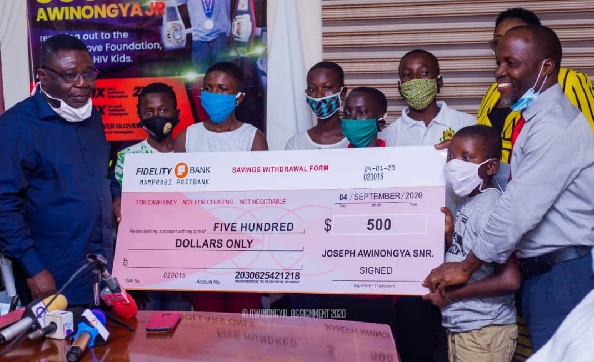 3. Rev John Azumah, the founder of Motherly Love Foundation (right) receiving the dummy cheque from the the CEO of the Ashaiman Municipal Assembly, Albert Okyere