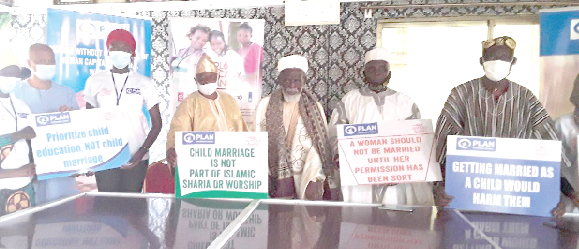 Sheikh Dr Osmanu Nuhu Sharubutu (3rd right), together with some officials of Plan International Ghana and members of Youth Advocates of GAA, holding placards seeking to end child and forced marriages in Ghana