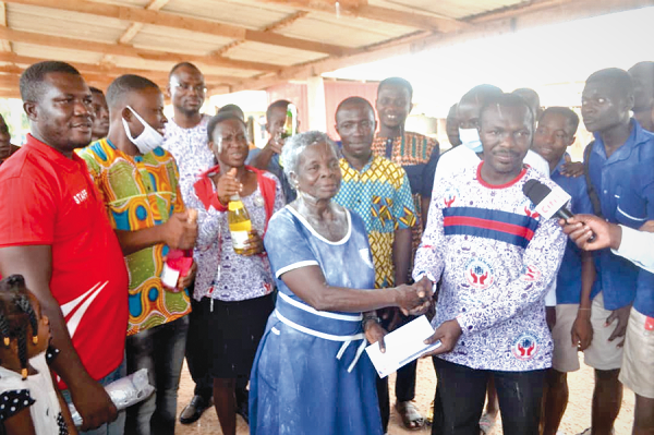  Mr Shad Nii Kotey Djanie (right) the Loans Officer of the STCCU making the cash donation to Madam Elizabeth Yamoah while others look on