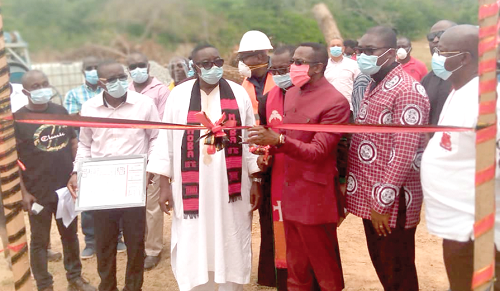 Mr Kwamena Duncan cutting the sod for the commencement of the project. Looking on are the headmaster, Rev Aidoo (left)  and other dignitaries