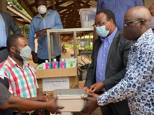 Dr Mathias Bebobru (2nd right) supported by Mr Fred Polkuu, a representative from the Nandom Traditional Area (right) presenting the items to Mr Francis Appiah at the hospital.