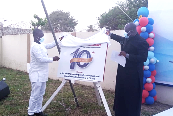  Rev. Dr Abraham Nana Opare Krakye (right) being assisted by Mr Percy Asare Ansah, CEO of Premier Health Insurance, to unveil the logo for the 10th anniversary celebration of the company